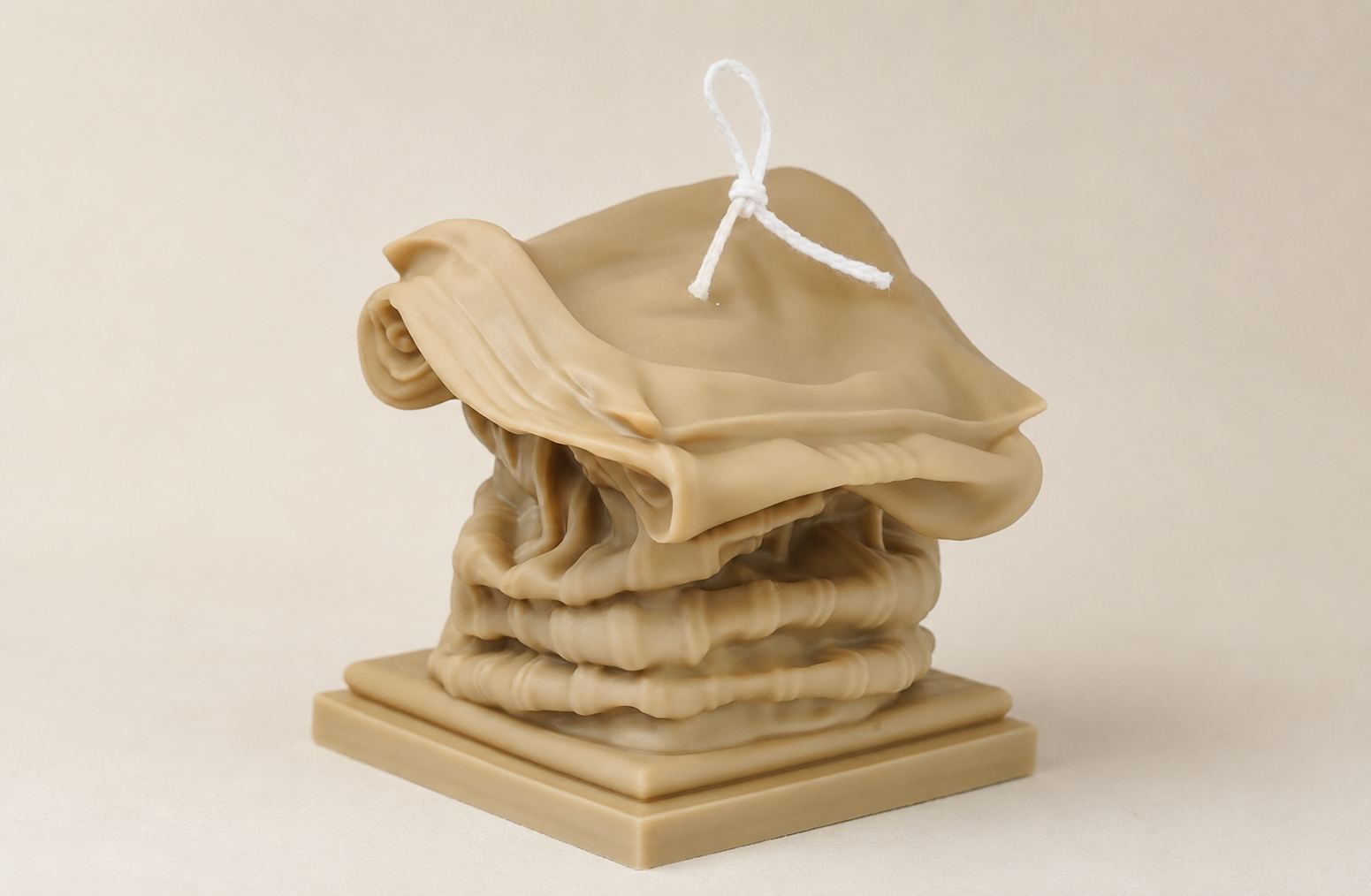 Custom sculptural candle in a folded fabric form developed by ZLCandle for complex molded candle production.